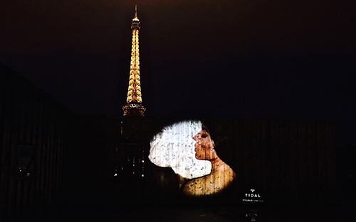 hot lady's face projected in front of the eiffel tower