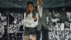a hot couple poses infront of a miniature cityscape